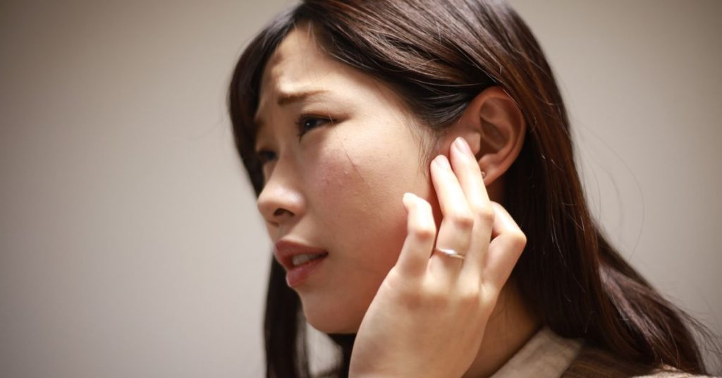 Adult experiencing ear pressure caused by seasonal allergies