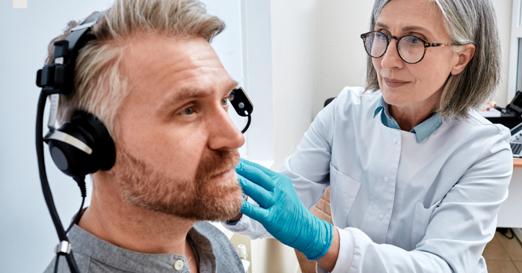 Older adult undergoing a hearing test to assess hearing loss reversibility