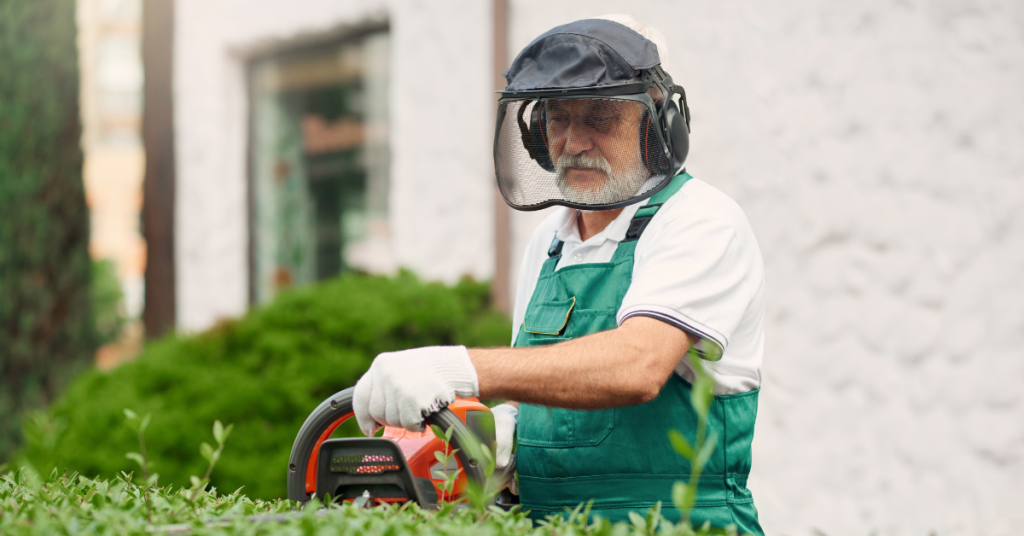 Elderly man using hearing protection outdoors to prevent noise-induced hearing loss