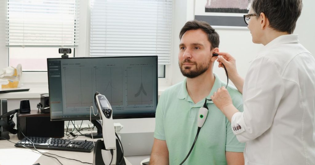 Older adult using hearing aid to manage tinnitus and hearing loss