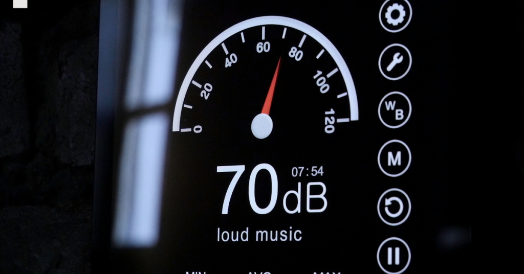 Smartphone displaying a sound meter app measuring noise in a loud environment