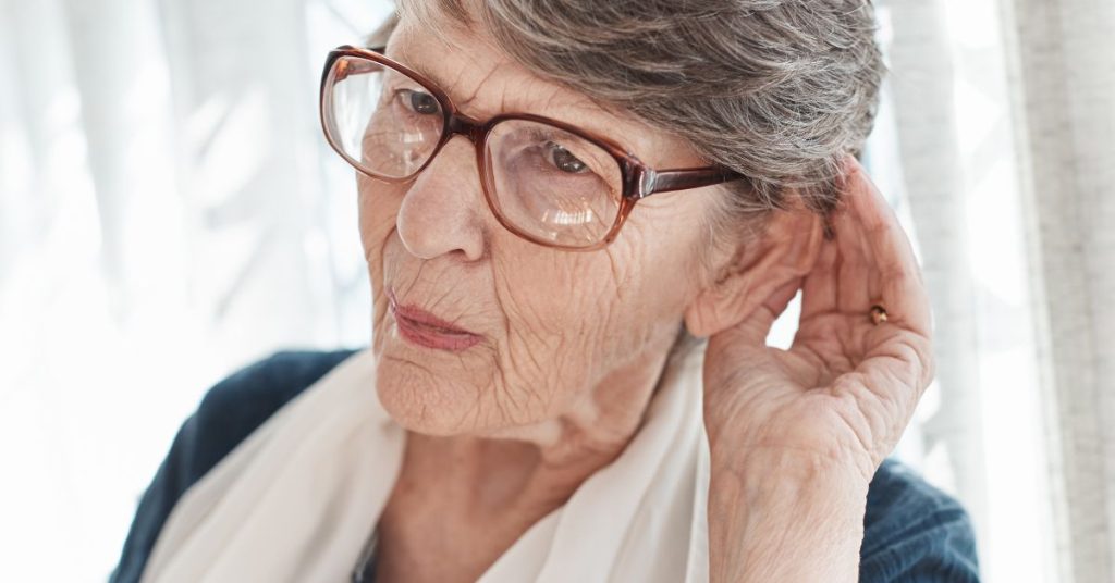 Adult experiencing muffled speech and trying to hear clearly