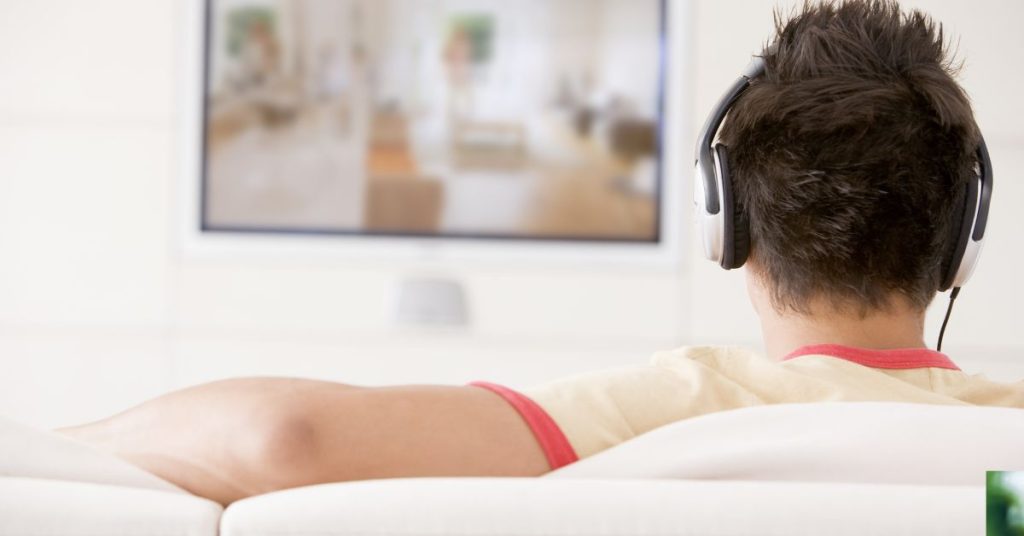 Senior using a hearing device to hear TV dialogue more clearly