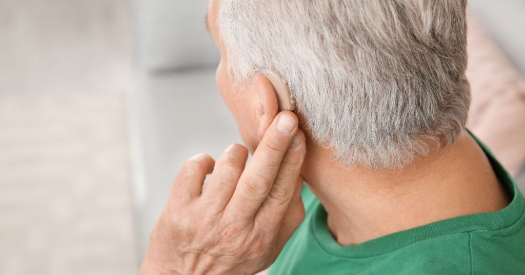 Older adult receiving support for hearing aids