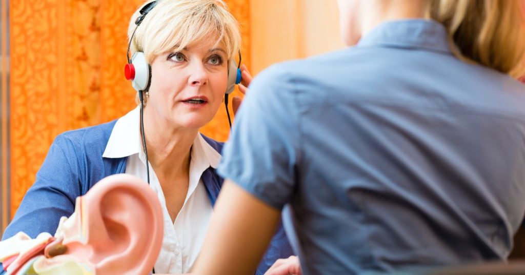 Senior adult receiving a free hearing test from an audiologist