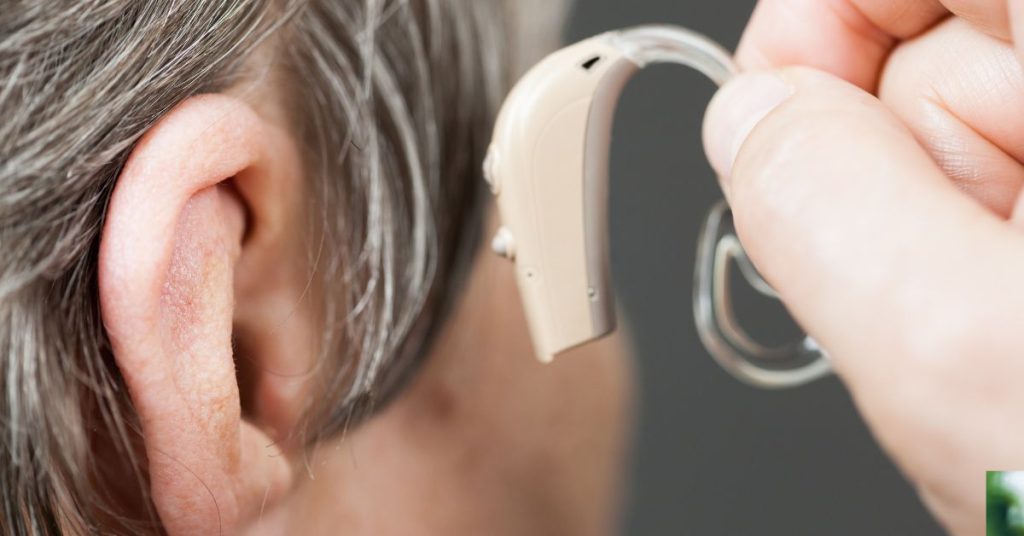 Senior adult using a hearing aid with care tips displayed