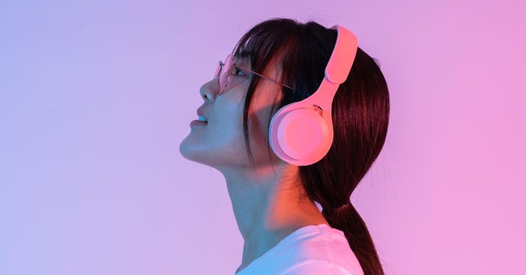 Teen listening to loud music through headphones and risking hearing damage