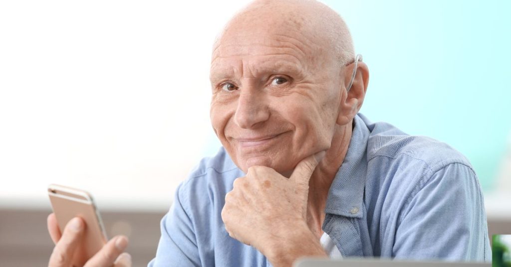 Senior adult streaming music to hearing aids with smartphone