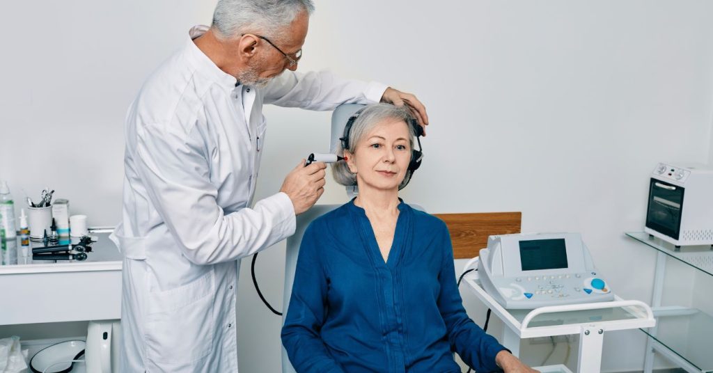 Older adult receiving an annual hearing test from an audiologist