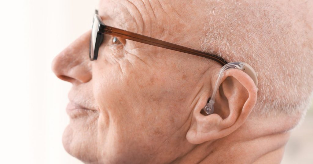 Older adult traveler with hearing aids exploring a scenic destination