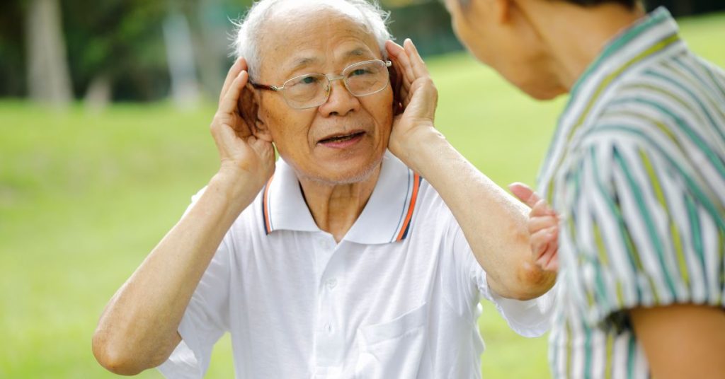 Older adult experiencing difficulty hearing during conversation
