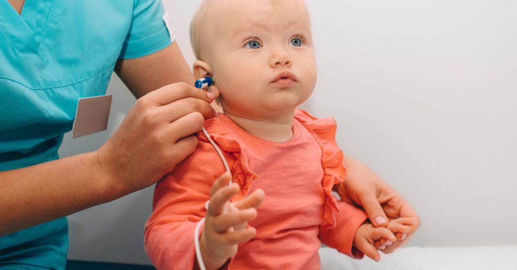 Parent and audiologist testing a child’s hearing